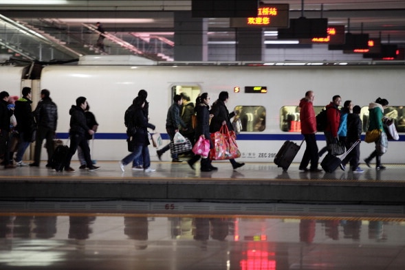 passengers alight a fast train at a Chinese train station