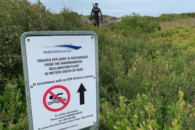 A sign warning people about the discharge of effluent into the water nearby.