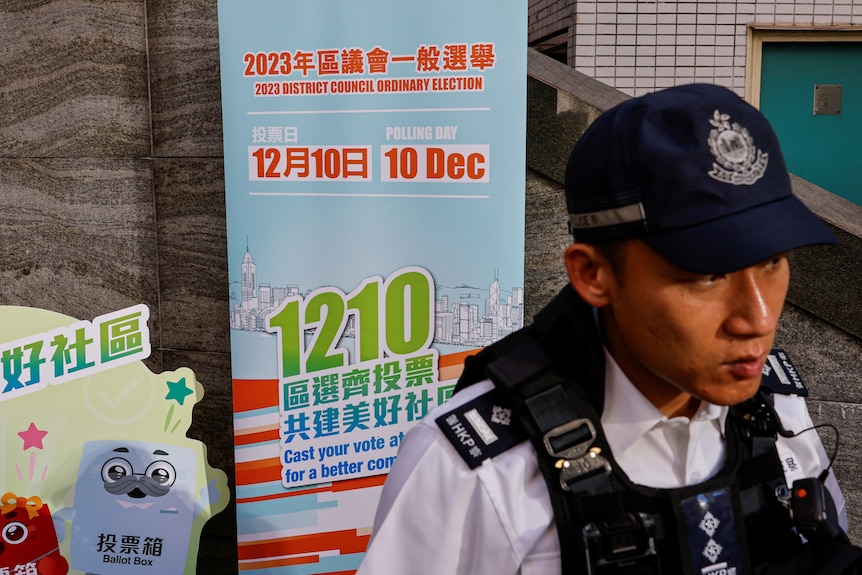 A police stands guard outside a polling station during the District Council election.