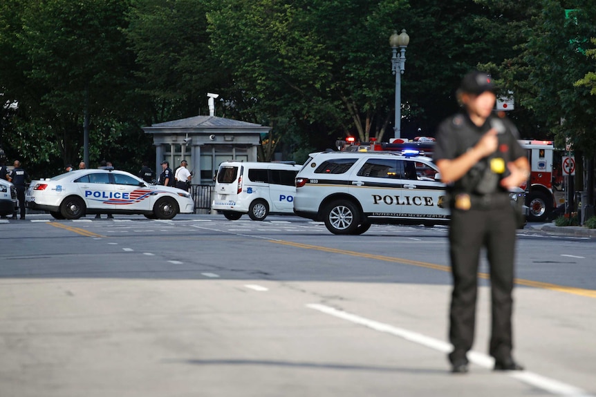 Police stand outside the White House after a person was shot