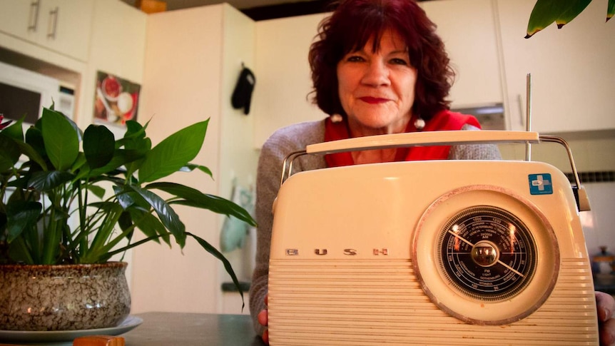 Clare Abrahams is in her kitchen holding a digital radio.