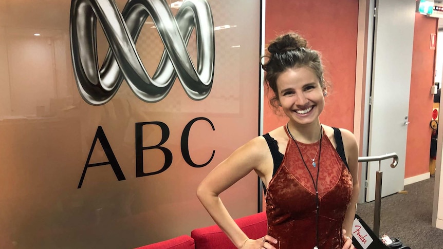 Imogen Clark standing in front of an ABC Radio sign.