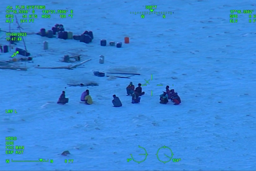Night vision of a group of people huddled on a beach