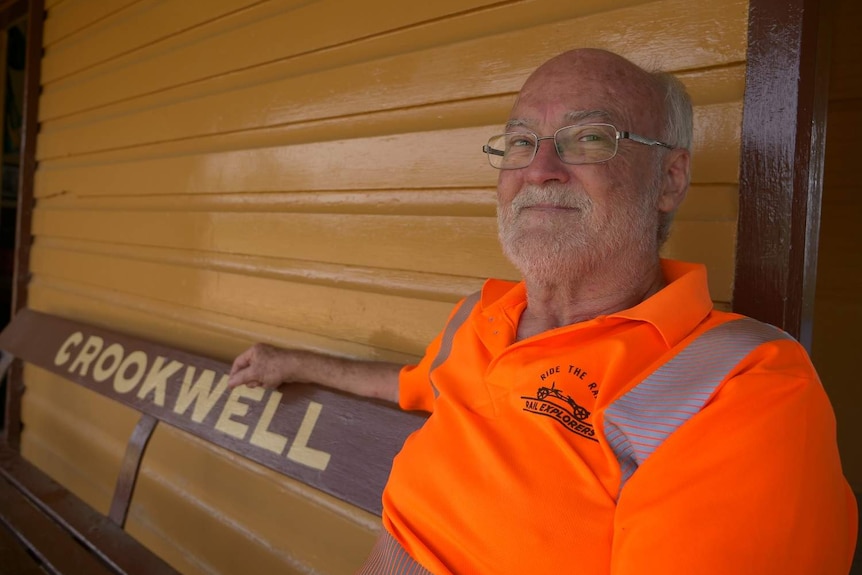 A man sitting on a bench at a historic train station.