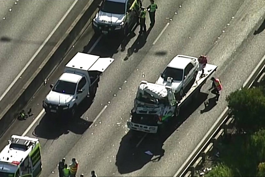 An overhead view of a damaged truck being removed from a road.