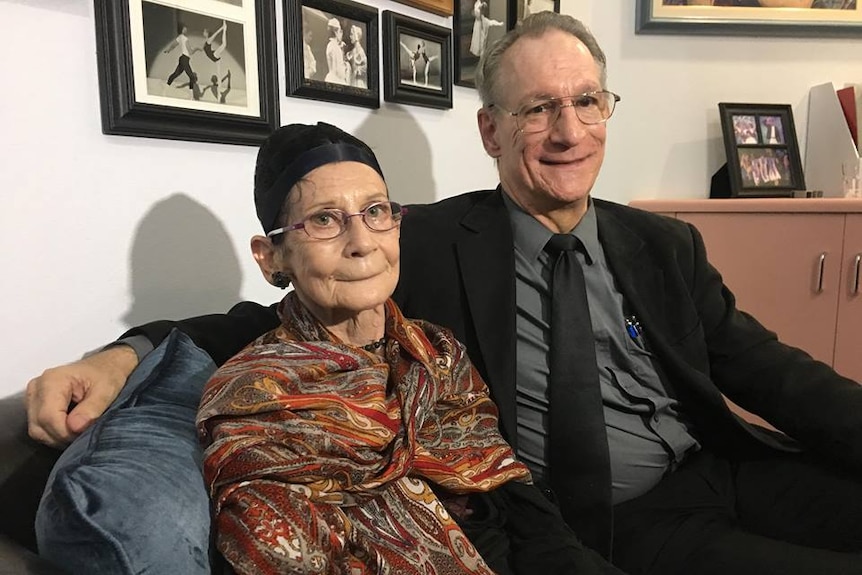 A man and woman sit beside each other on a lounge.