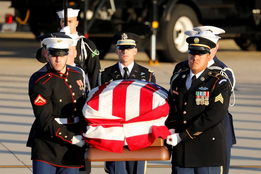 A military honour guard carries the casket of former US president George HW Bush.