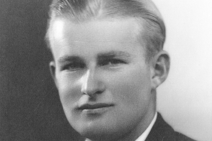 A black and white historical photo of a young man wearing a suit