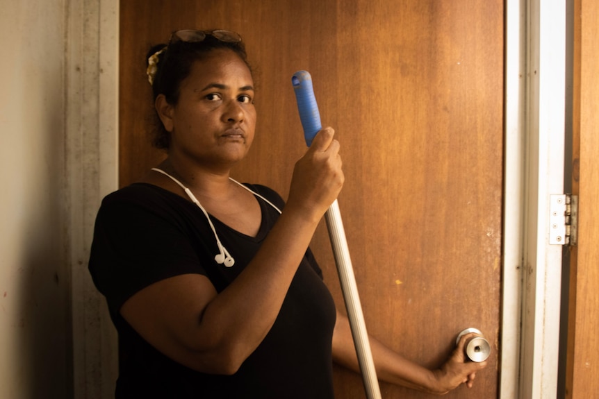 A portrait of a woman holding a mop.
