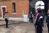 A tour group learns the history of Boggo Road Gaol.