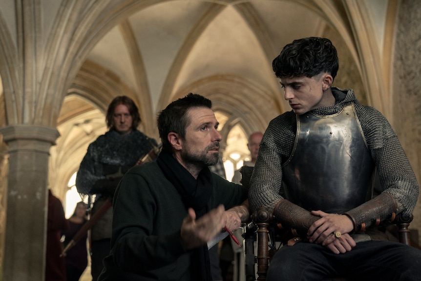The two men are in conversation on set, Timothee wearing chain mail.