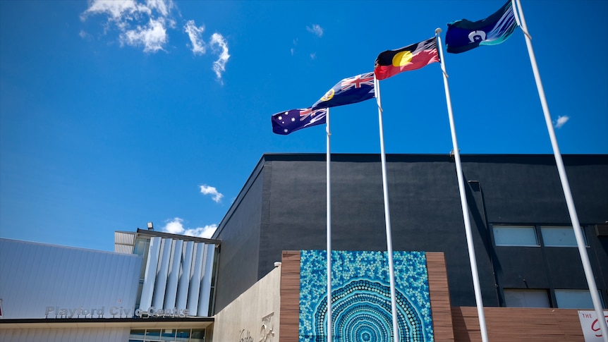 A building with flags flying in the front and the words Playford Civic Centre written on it