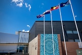 A building with flags flying in the front and the words Playford Civic Centre written on it