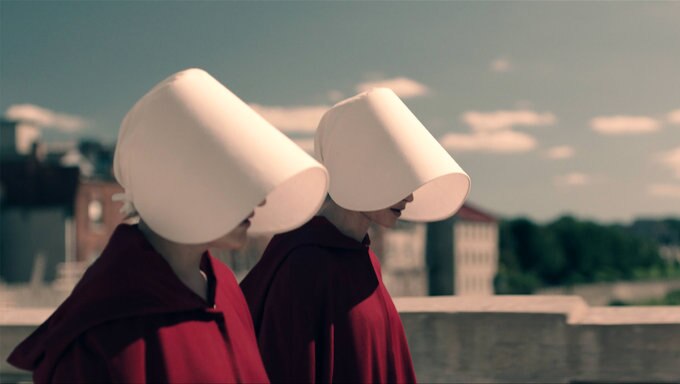 Image of two women wearing red with white cloth over their heads.