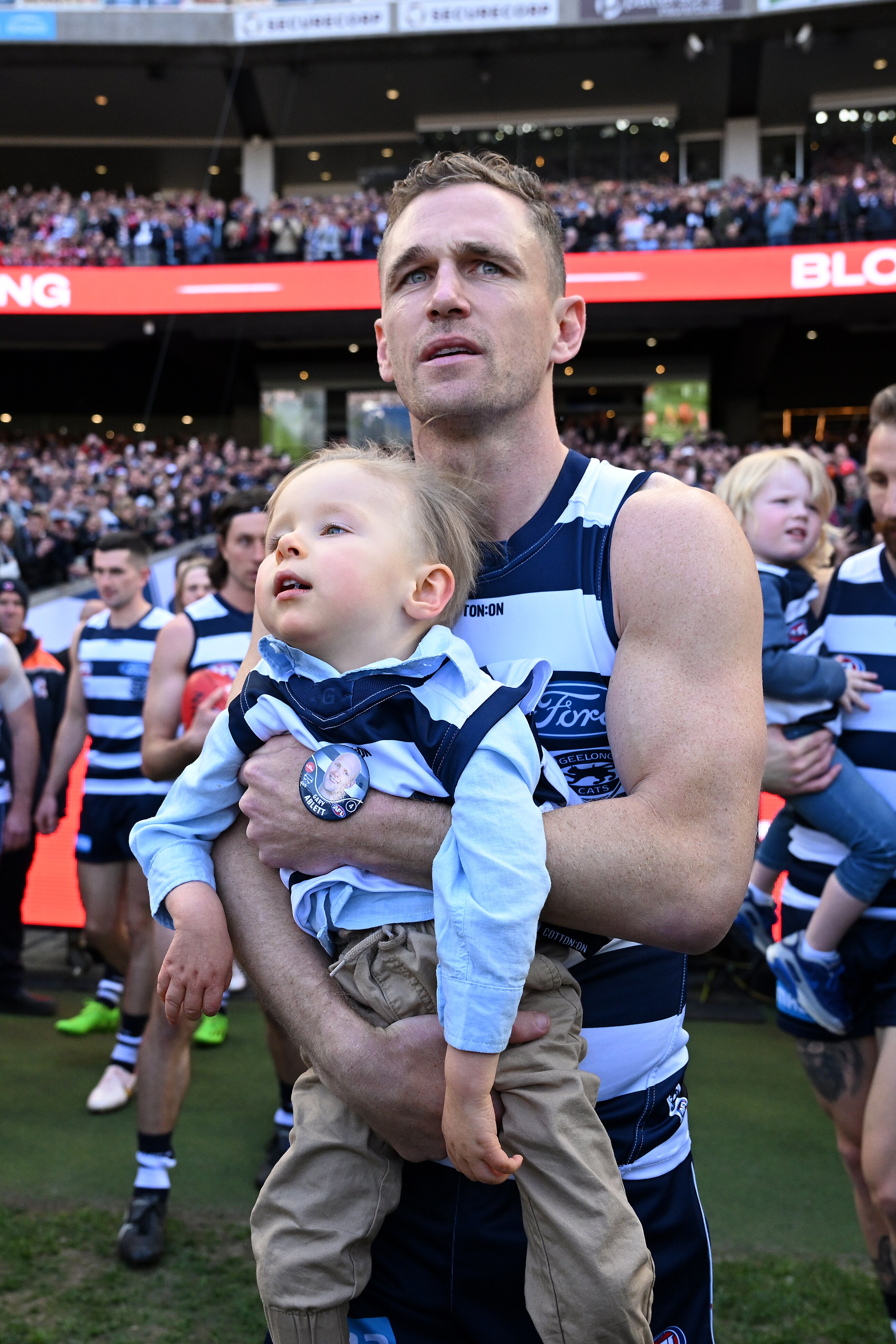 Joel Selwood of Geelong carries out with Levi Ablett onto the field ahead of the AFL Grand Final.