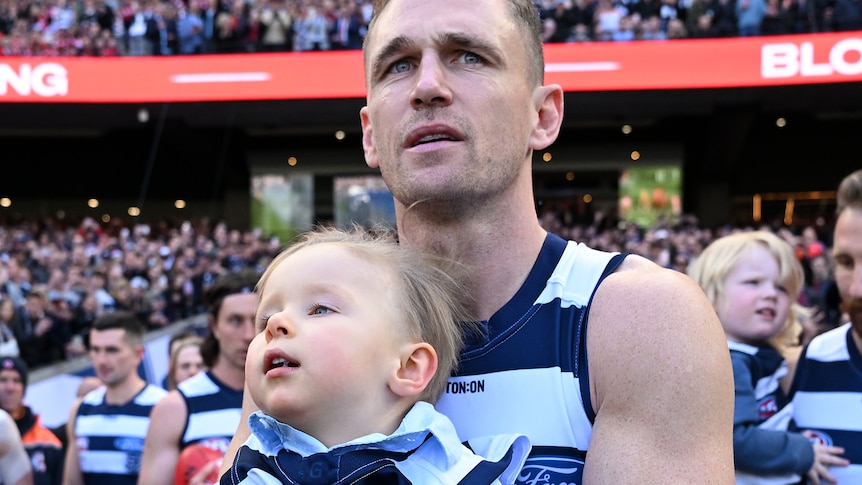 Joel Selwood of Geelong carries out with Levi Ablett onto the field ahead of the AFL Grand Final.