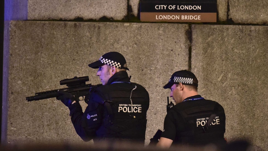 An armed police officer looks through his weapon on London Bridge.