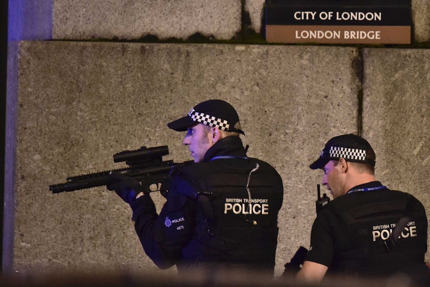 An armed police officer looks through his weapon on London Bridge.