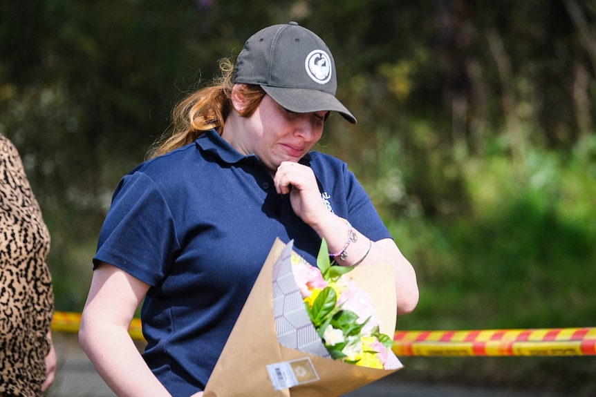 A girl crying while holding flowers