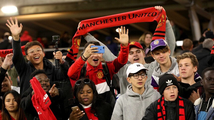Manchester United fans hold up