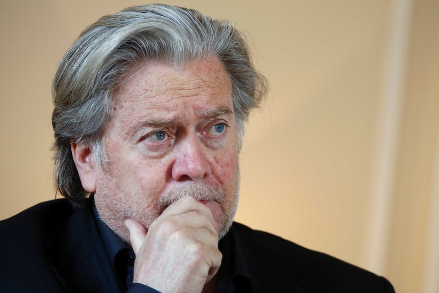 Close up of Steven Bannon's head as he looks to the right, while wearing a black turtleneck