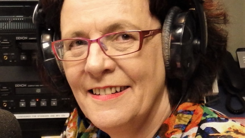 Julie Simonds wearing radio headphones in the studio. 