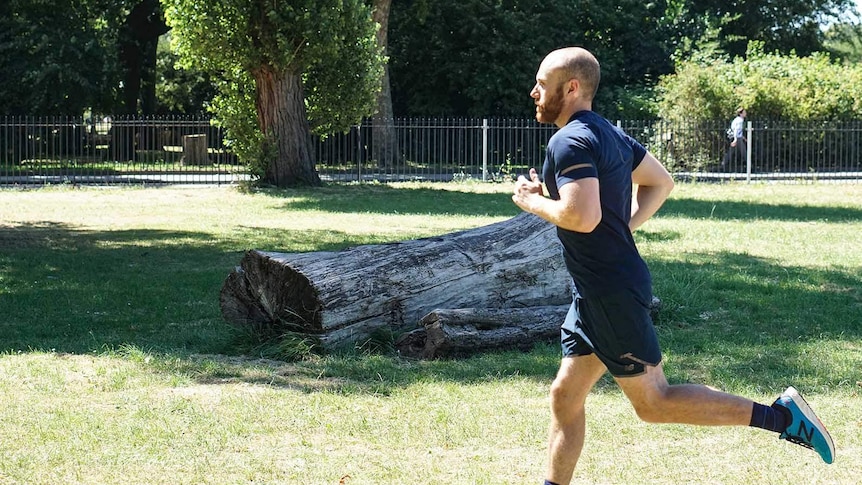 A man with a beard jogging on a sunny day