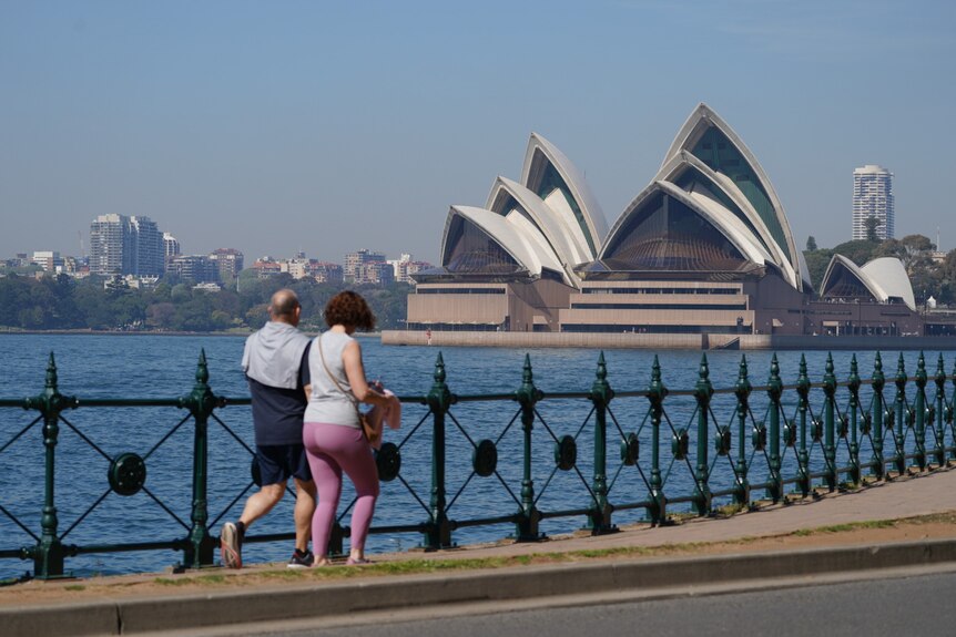 Two people walking around Sydney Harbour