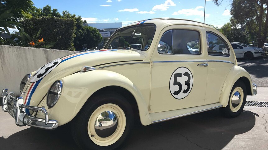 Side view of Herbie the Love Bug replica parked in driveway.