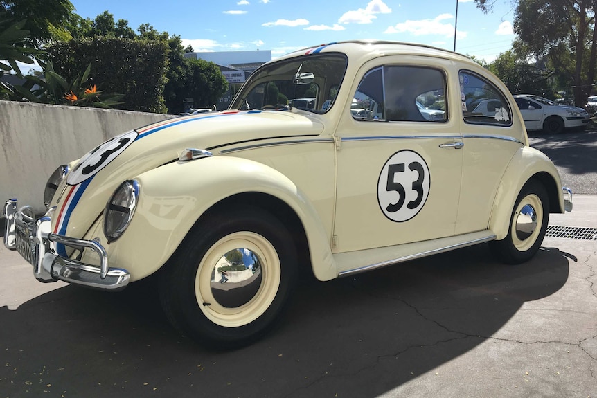 Side view of Herbie the Love Bug replica parked in driveway.