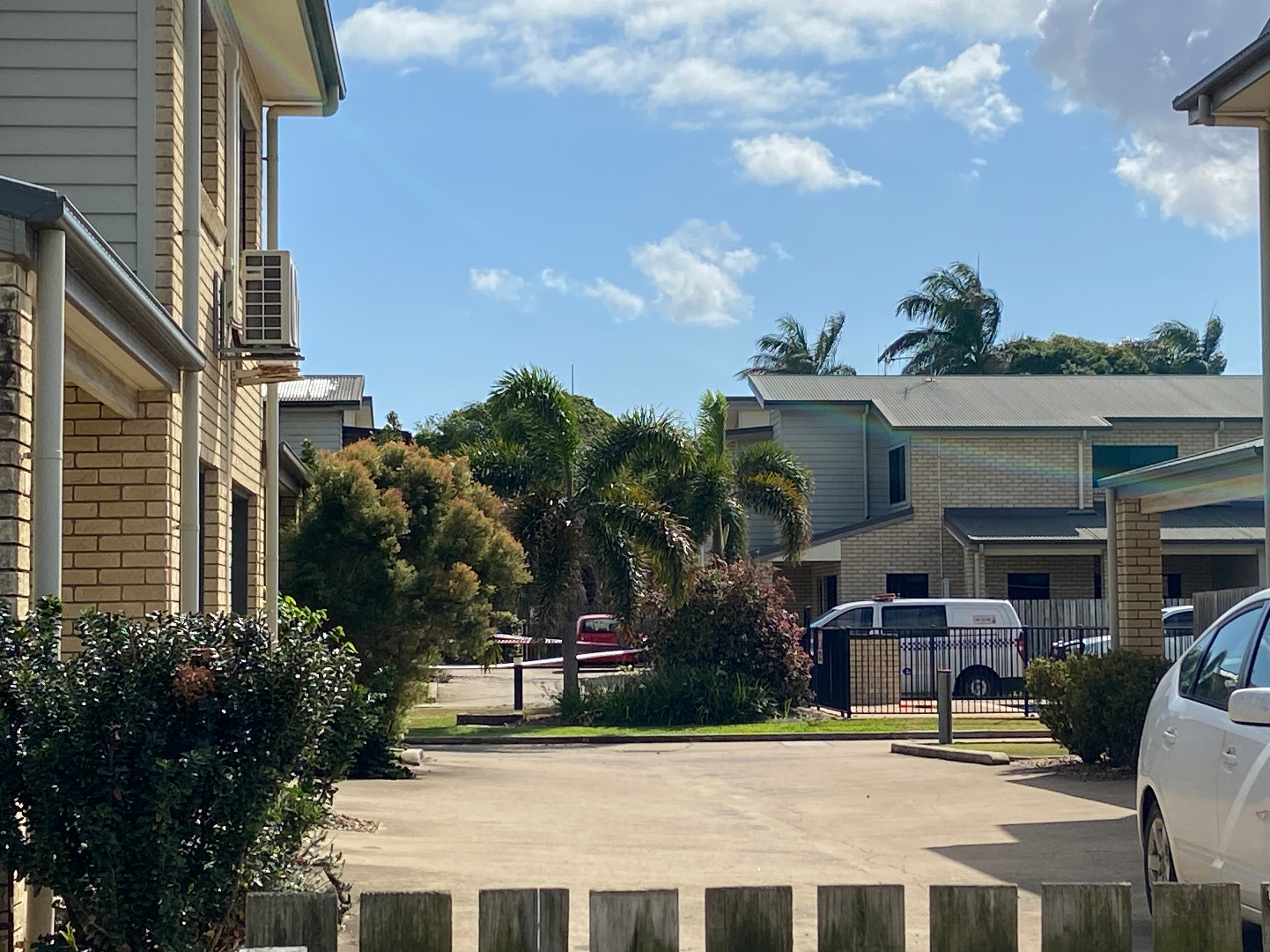 Police tape in the distance at a block of units