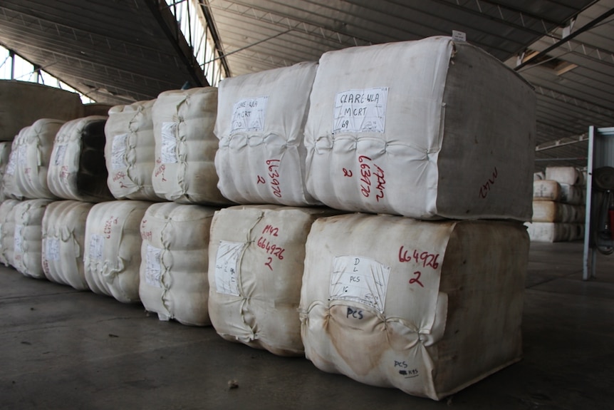 Stacked bales of wool inside a warehouse.
