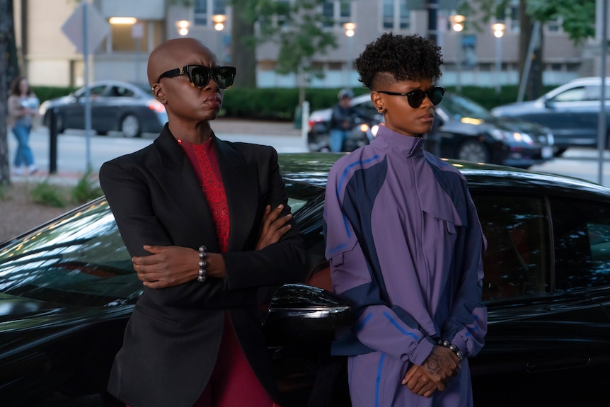 Two black women in sunglasses, one with a bald head