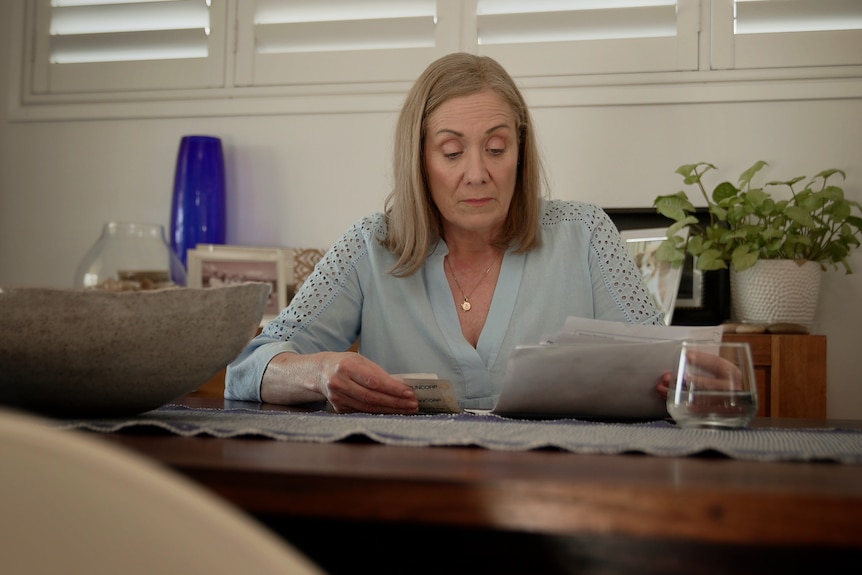 Jo O'Halloran looks through bills in her home.
