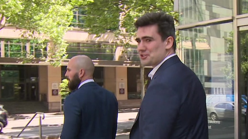 Two men walking away from cameras outside County Court in Melbourne