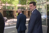 Two men walking away from cameras outside County Court in Melbourne