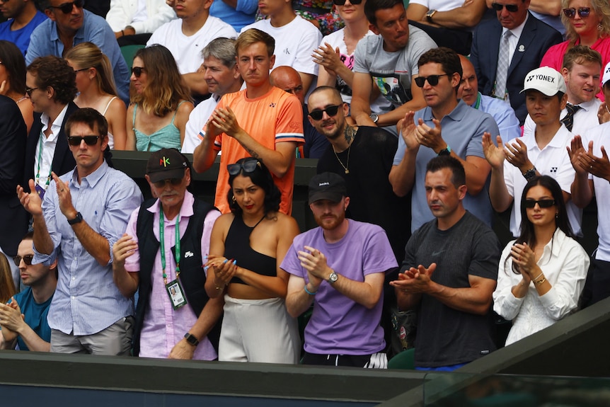 Nick Kyrgios's support team clap during the Wimbledon men's singles final.