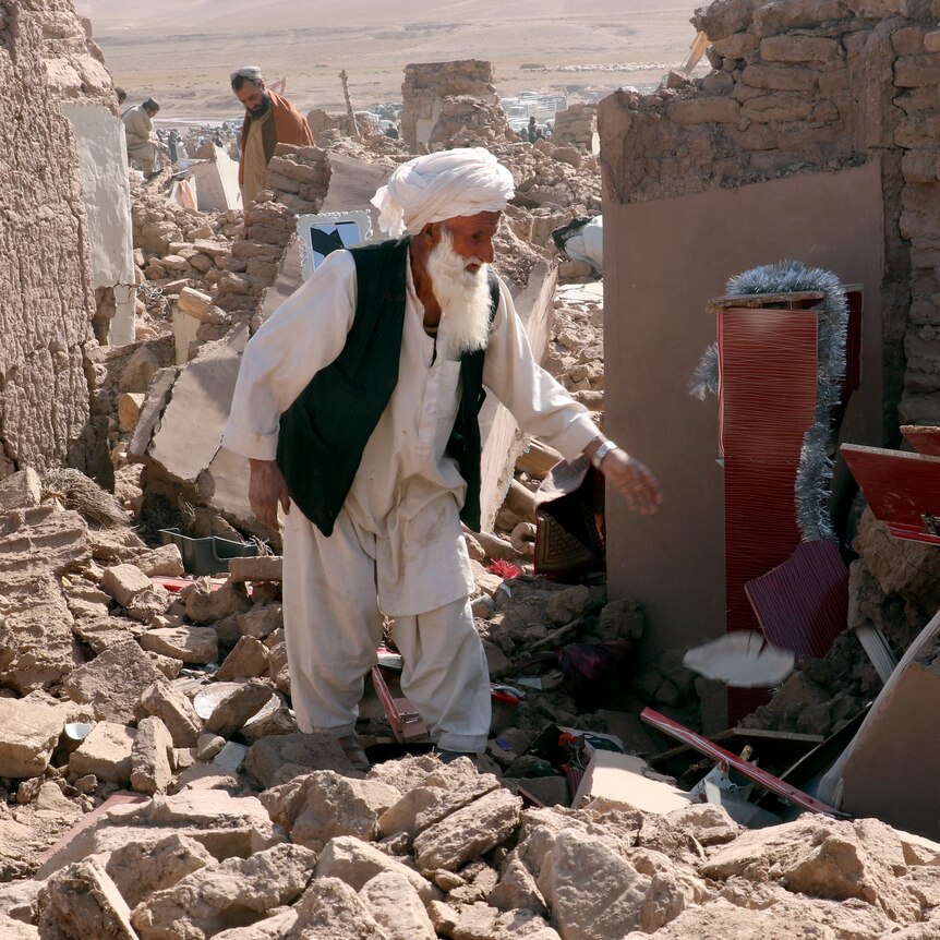 A man standing among the wrecks after an earthquake. 