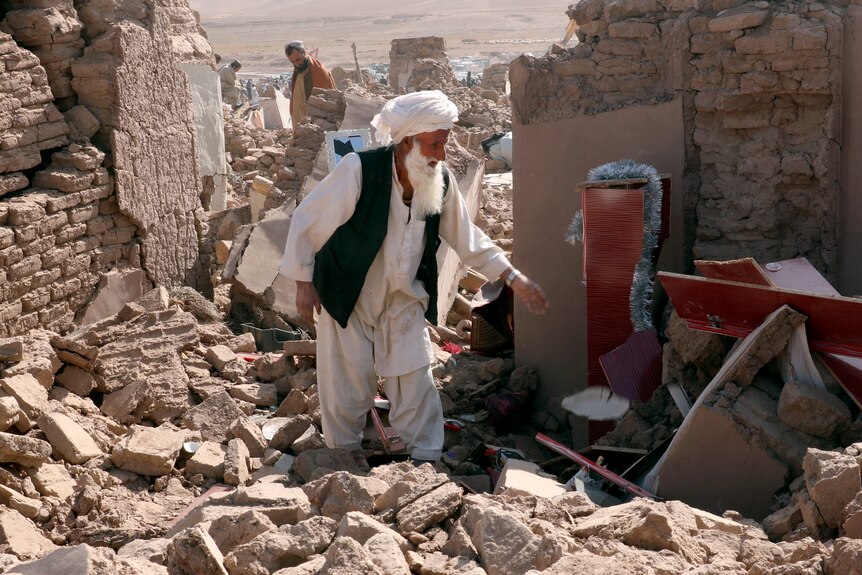 A man standing among the wrecks after an earthquake. 