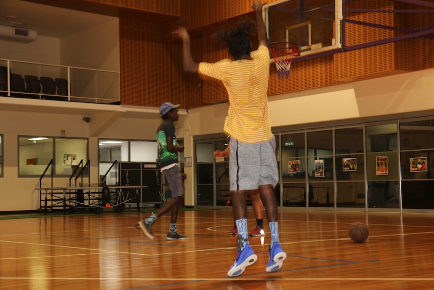 Players wearing ankle trackers shoot hoops with other junior players at the Palmerston and Regional Basketball Association