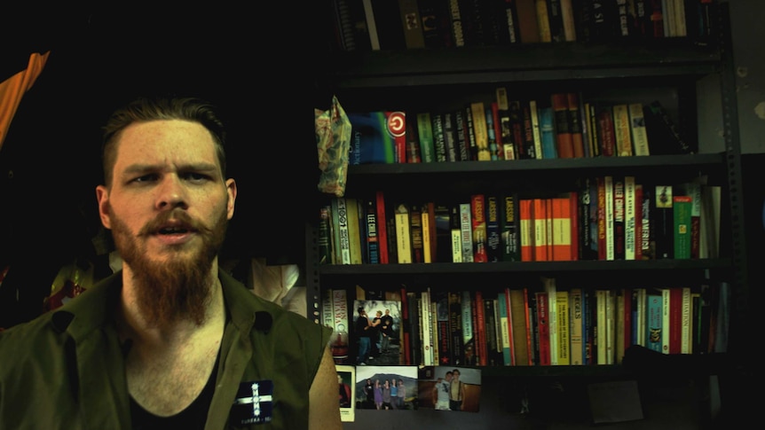 Jock Palfreeman in front of his prison bookshelf