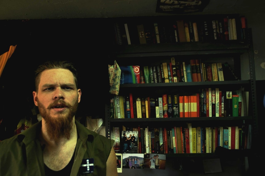 Jock Palfreeman in front of his prison bookshelf