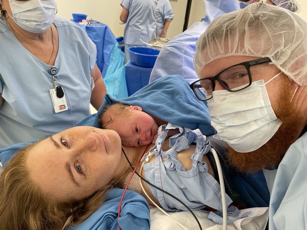 A white woman lying in a hospital bed after giving birth