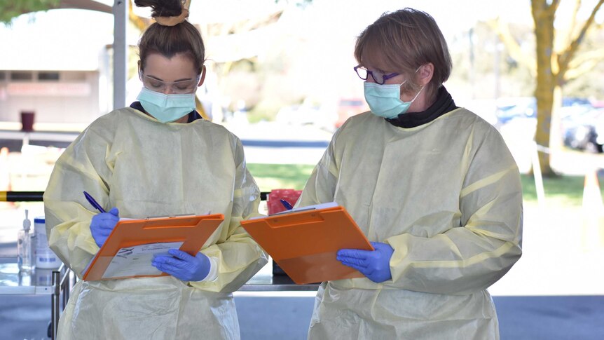 Two pathology staff check paper work at a Mount Gambier Covid testing site