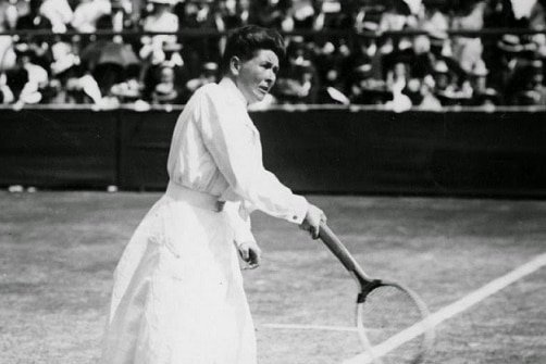 A black and white photo of Charlotte Cooper playing tennis.