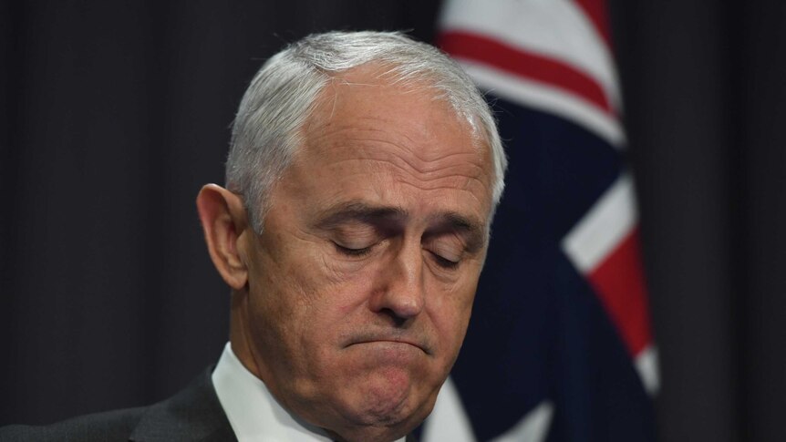 Malcolm Turnbull looks down with a solemn expression as he addresses media after a terrorist attack in London.