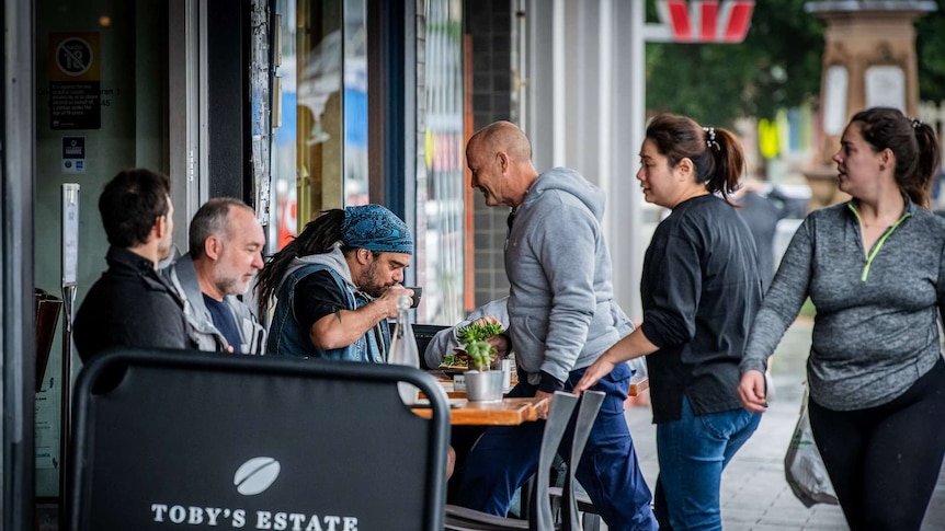 Patrons sit outside a busy cafe in Sydney.