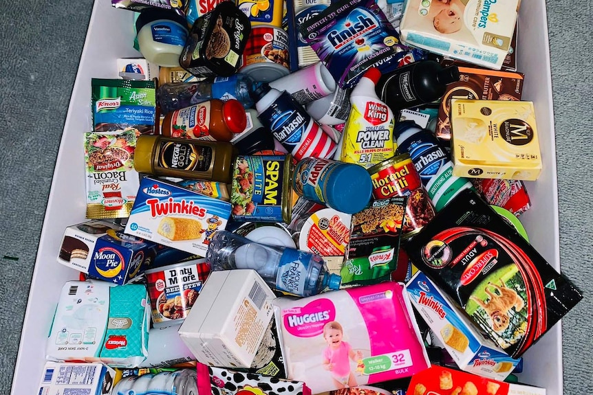 A basket of Coles' Little Shop collectible toys, including miniature baby wipes and washing powder