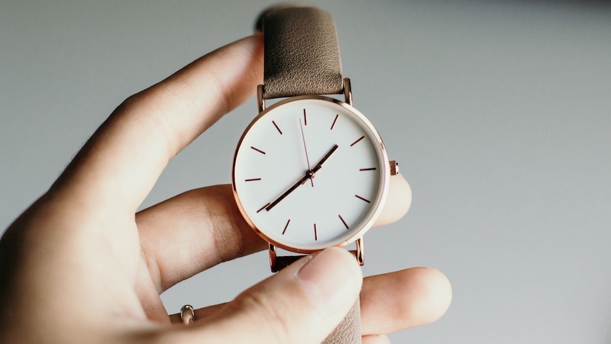 A close up of a watch on an arm  