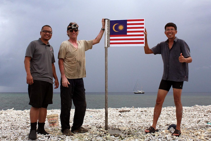 Hans Berekoven and Malaysian colleagues with Malaysian flag on Luconia Shoals
